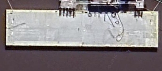 Vista aérea de un muelle de carga con una barcaza sobre el río
