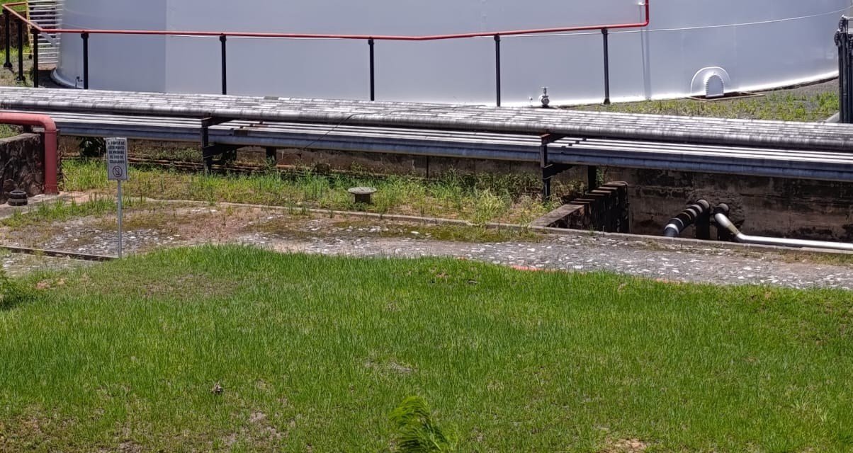 Base de un tanque de almacenamiento con cañerías y área perimetral